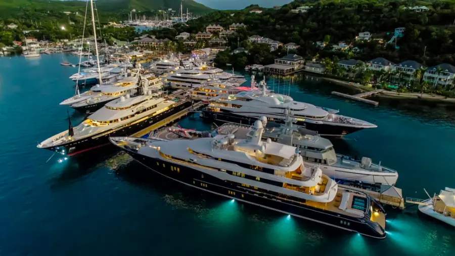 Superyachts lit up along the docks at twilight