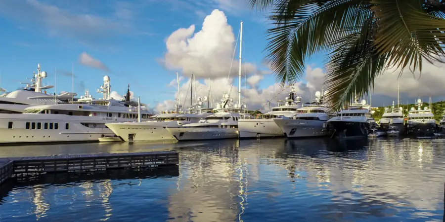 Superyachts moored along the dock under a bright Caribbean sky